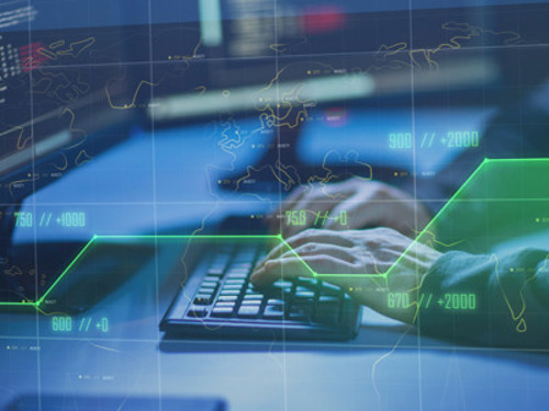 En person som skriver på ett tangentbord framför en bildskärm.