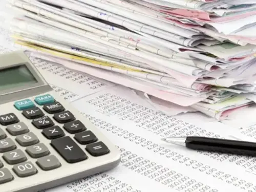 En miniräknare som ligger på en hög med papper.