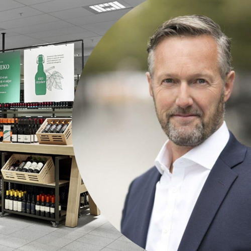 En man står framför en vinbutik.