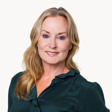En kvinna i grön skjorta poserar för en bild.