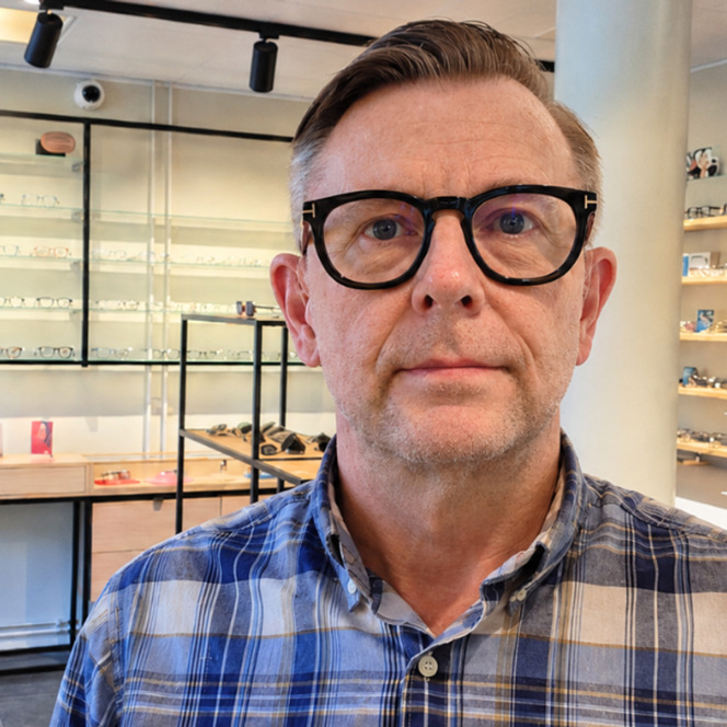 En man som står framför ett glasutställningsfönster.