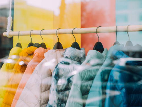 En rad färgglada rockar som hänger på en klädstång.